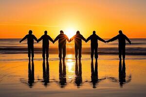Silhouette of people holding hands at sunrise on the beach photo