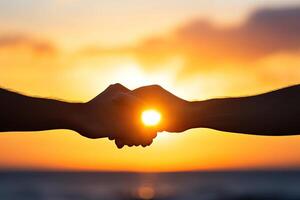 Two hands clasped in sunset photo