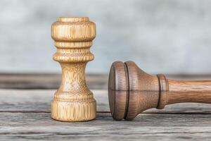 Wooden chess pieces, light and dark, on rustic wood photo