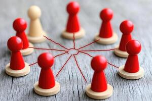 A group of red wooden pawns on a wooden table photo