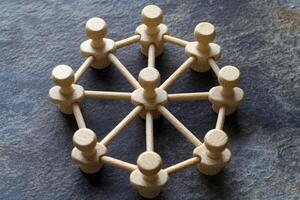 Wooden figures interconnected in a circular network photo