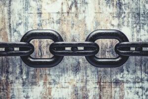 Dark chain links on weathered surface photo