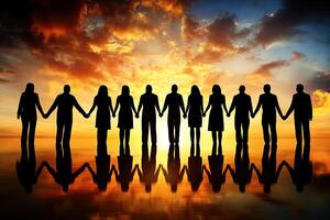 Silhouettes of people linked hands, sunset background photo
