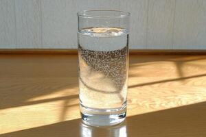 Clear glass tumbler filled with carbonated water photo