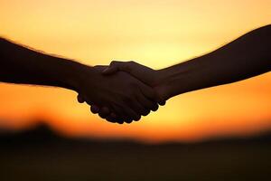 Two hands shaking at sunset photo