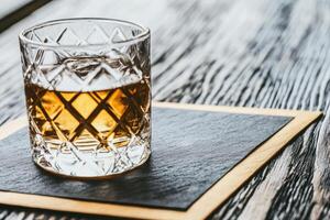Whisky in a crystal glass on a dark slate coaster photo
