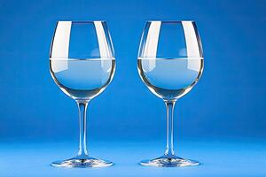 Two identical wine glasses filled with water photo