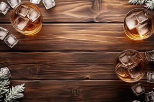 Two glasses of amber liquid with ice on a wooden table photo
