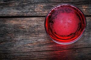 Red Drink in a Glass on Wooden Surface photo
