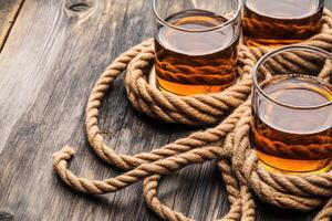 Three drinks on rustic wood, tied with rope photo