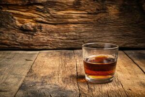 Single glass of amber liquor on rustic wooden table photo