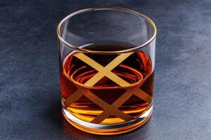 Amber liquid in a glass tumbler with gold diamond pattern photo