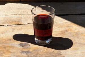 Red wine glass on rustic wooden table photo