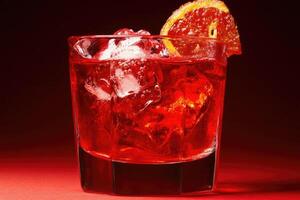 Crimson cocktail with ice and orange slice photo
