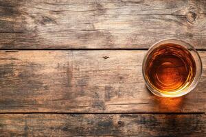 Whiskey glass on rustic wood photo