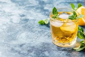 Refreshing iced tea drink garnished with fresh mint and lemon photo