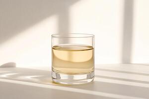 Clear glass tumbler with light yellowish liquid photo