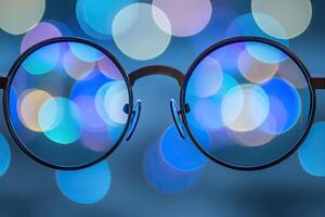 Round eyeglasses reflecting bokeh photo