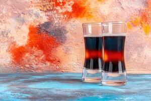 Two layered shots of dark alcoholic beverage photo