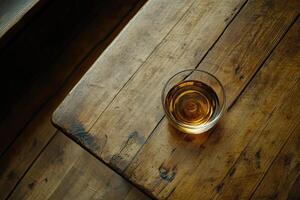 Amber liquid in glass on rustic table photo