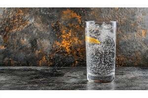 A glass of water with ice and a lemon slice photo