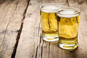 Two glasses of beer on a wooden table photo