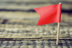 Small red flag on weathered wood photo