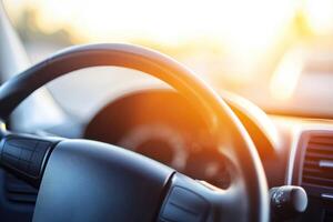 Close-up view of a car dashboard with steering wheel. Sunlight streams into the vehicle's interior photo