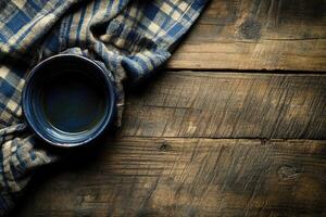 Empty dark blue bowl on rustic wooden table with checkered cloth photo