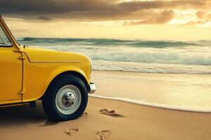 Retro yellow car on beach at sunrise photo