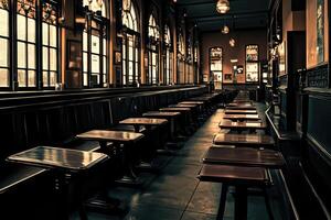 Empty, dimly lit pub interior. Long rows of tables and benches line the room photo