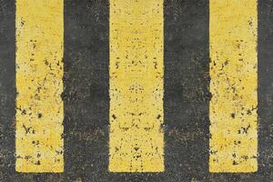 Yellow stripes on dark asphalt photo