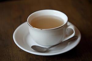A cup of light-colored beverage on a wooden table photo