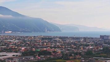 Aerial view of Pompeii's ruins, modern structures, and Mount Vesuvius. The camera glides over the urban landscape, fields, and distant coastline. video