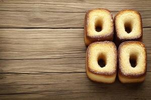 Four square pastries with holes, dusted with sugar, on a rustic wooden surface photo