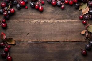 Autumnal berries frame on rustic wood photo