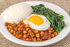 Hearty chickpea curry with rice and spinach photo