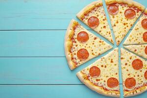 Pepperoni pizza slices on teal wood photo