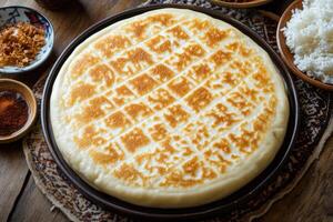 Round, patterned flatbread, golden-brown top photo