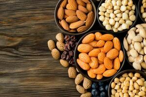 Assorted nuts and dried fruits in small bowls photo
