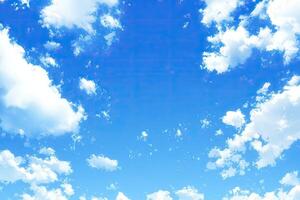 Clear, vibrant blue sky dotted with fluffy white clouds photo