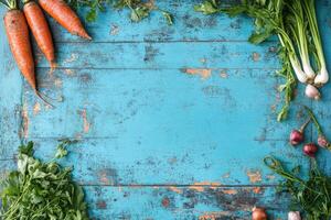 Fresh, vibrant vegetables arranged on a textured blue wooden surface photo