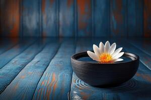 Tranquil lotus blossom in dark bowl on wooden surface photo