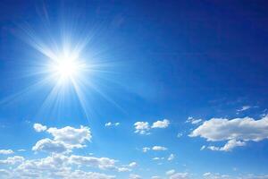 Bright sun, clear blue sky with clouds photo