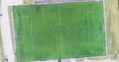 ascending footage soccer field and players of a team training, aerial top down view with drone video