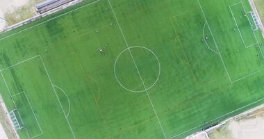 hovering footage soccer field and players of a team training, aerial overhead top down view with drone video