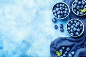Fresh blueberries in bowls on a textured blue background photo