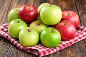 Fresh red and green apples on a checkered cloth photo