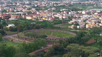 Aerial view of Pompeii's urban layout with colorful buildings, green spaces, and Mount Vesuvius in the background. Smooth sweeping camera motion. video