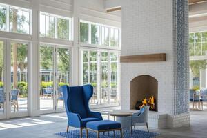 Light-filled common area with a fireplace and large windows photo